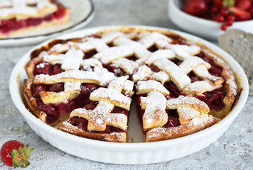 Cake with cherries and icing sugar on a concrete background. Sliced Cherry Pie.