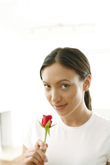 Young woman smelling rose