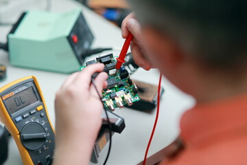 Hands of a man are engaged in the repair of electronics. Services, Manual assembly of the soldering...