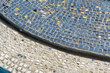 blue and yellow colorful mosaic flooring on the floor of the water pool. Blue and white mosaic tiles as a background..