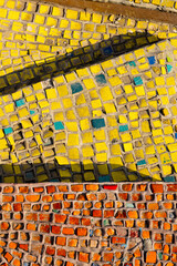 Close-up of a yellow and red mosaic design. Colourful mosaic background, vertical image.