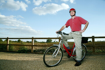 Senior man with helmet posing on bicycle