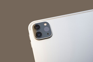 2020 new 12.9 tablet dual camera with LIDAR sensor, on background. Close-up of tablet computer camera system on a brown background.