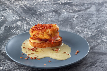 Eggs Benedict on toasted muffins with ham and sauce