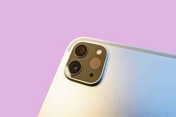 Close-up of tablet computer camera system on a pink background. Light detection scanner on a modern digital multimedia device.