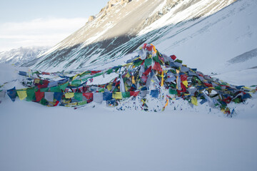 Prayer flags at Thorung La Pass summit covered in heavy snow, Annapurna circuit, Nepal