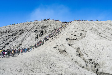 Large amount of tourists queup up to climb visit  famous active volcano crater, Mount Bromo, East Java, Indonesia, July 2019