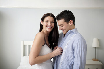 Woman unbuttoning man's shirt