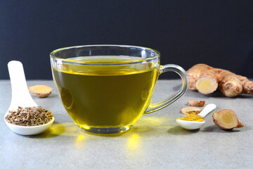 Cumin tea also known Jeera tea or Jeera water in a glass cup with cumin seeds in a spoon