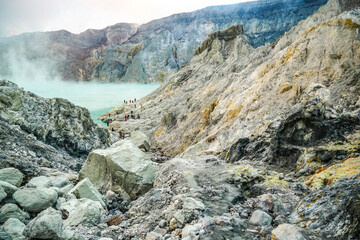 Emerald green sulfur acid lake and toxic gas at the bottom of active volcano crater, Kawah Ijen, East Java, Indonesia