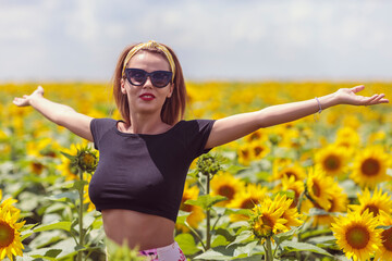 Pretty young woman on a sunflowers field
