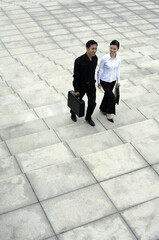 Businessman and businesswoman walking up the stairs