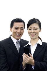Businessman and businesswoman looking at mobile phone