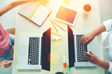 Two freelancers write articles for the client. Bloggers use their laptops and tablet for the search...