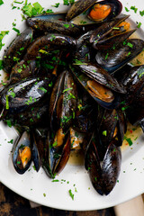 Mussels. Classic French or American restaurant appetizer: steamed mussels. Shellfish steamed with white wine, butter, garlic, onions and fresh herbs. Served with butter toasted baguettes.