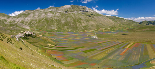 Castelluccio di Norcia, Italy - July 2020: wide view with the town on the left still rebuilding...