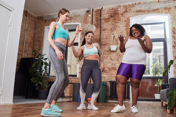 Young females standing close together enjoying dances indoors