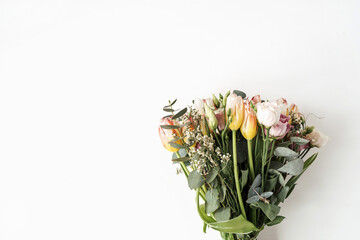 Tulip, eucalyptus flowers bouquet on white background. Flat lay, top view festive holiday celebration floral concept