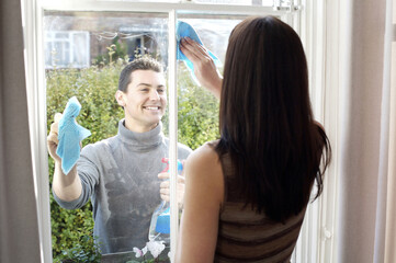 Couple cleaning the window together