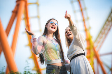 Group of happy best friends laughing and having fun at amusement park, holiday travel with friends concept