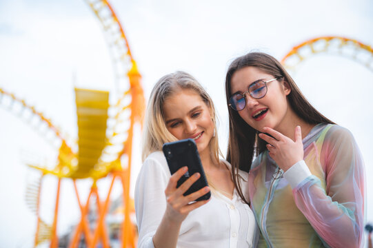 Group of happy best friends laughing and taking selfie photo at amusement park, holiday travel with friends concept