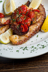 Octopus. Fresh caught octopus, seasoned with salt and pepper and grilled with olive oil and lemon juice. Served with a green leaf lettuce salad, heirloom tomatoes, red onions and Kalamata olives.