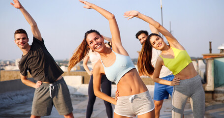 Fototapeta premium Group of happy fit people friends exercising together outdoor