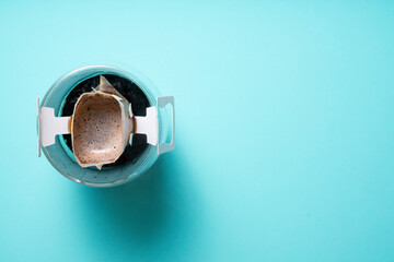 Instant freshly brewed cup of coffee on green background,Drip bag fresh coffee