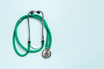 Top view of green medical stethoscope on colorful background with copy space. Medicine equipment...