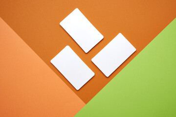 piles of white paper blank business cards on orange-green background