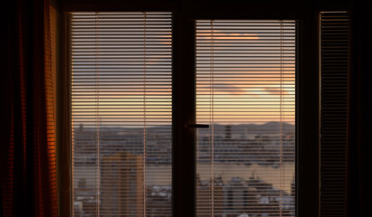 The sun shines through the blinds. Selective focus.