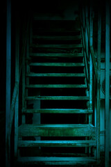 Mystical horror staircase to a dark basement, attic in an old decrepit scary abandoned house with paranormal blue green light and terrible frightening shadows causing fear