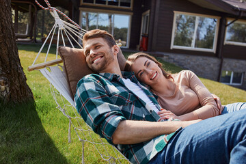Pretty young woman resting near her boyfriend outdoors - Powered by Adobe