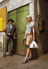 Two models get dressed up in 1930's style vintage 
clothing and act the part of the gangster duo 
Bonnie and Clyde. They are seen in the ruins of an 
old abandoned factory.