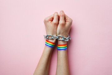 LGBT people discrimination and criminalization of homosexuality concept, hands with rainbow ribbon...