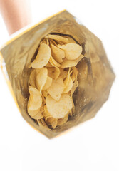 hand holds a potato snack on white background from top view