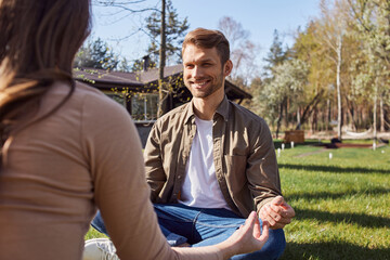 Fototapeta premium Smiling man sitting in lotus position and looking at his girlfriend