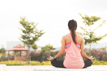 Close up girl hands, back view. Young women do yoga outdoors on stone. women exercising yoga in the...