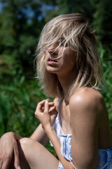 portrait of a girl with light hair in nature. Blonde face hair style. Close his eyes. Sunlight.