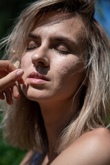 portrait of a girl with light hair in nature. Blonde face hair style. Close his eyes. Sunlight.