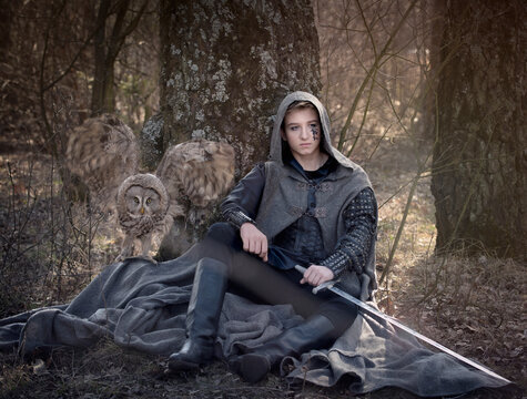 Art photo of a warrior man with a sword and owl with wings spread
