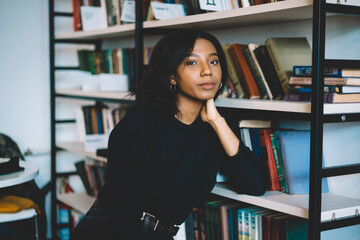 Serious black student spending time in library