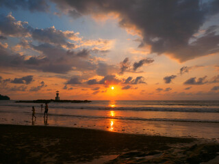 Tropical beach with lighthouse at sunset