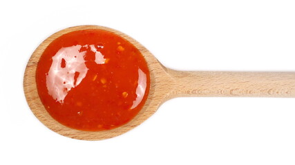 Chili sauce with wooden spoon isolated on white background, top view