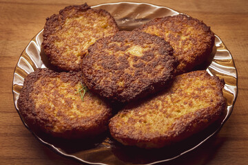 Five potato patties lie in a glass plate