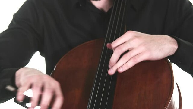 masterly musician in a black shirt performs a beautiful slow melody on a classical cello. Isolated. Medium long shot