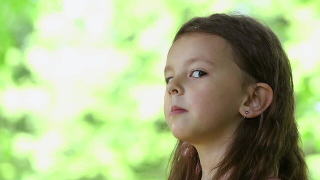 Large portrait of a little girl who dabbles in squinting her eyes left and right