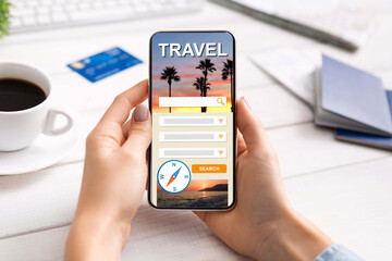 Woman using modern smartphone with travel booking website on screen