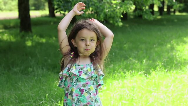 Little girl puffs out her cheeks and watches the soap bubbles fly