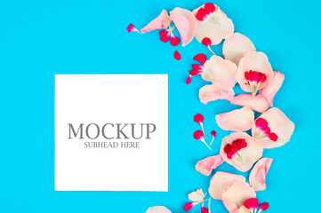 mockup of pink flowers and white paper on a blue background